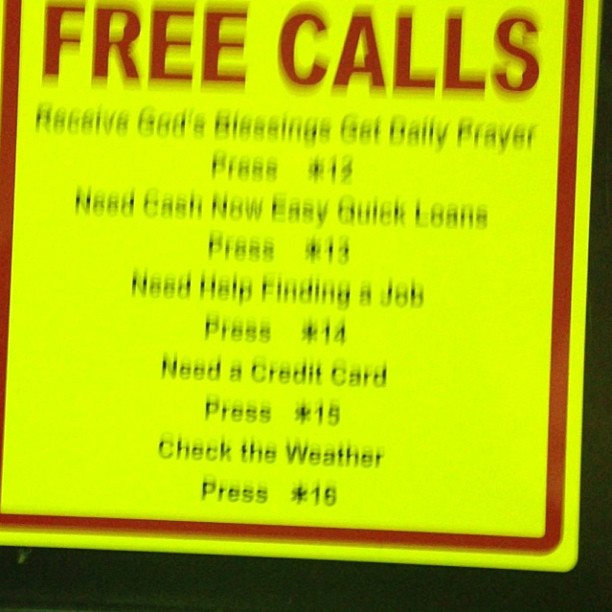 Blurry Sign Above Pay Phone